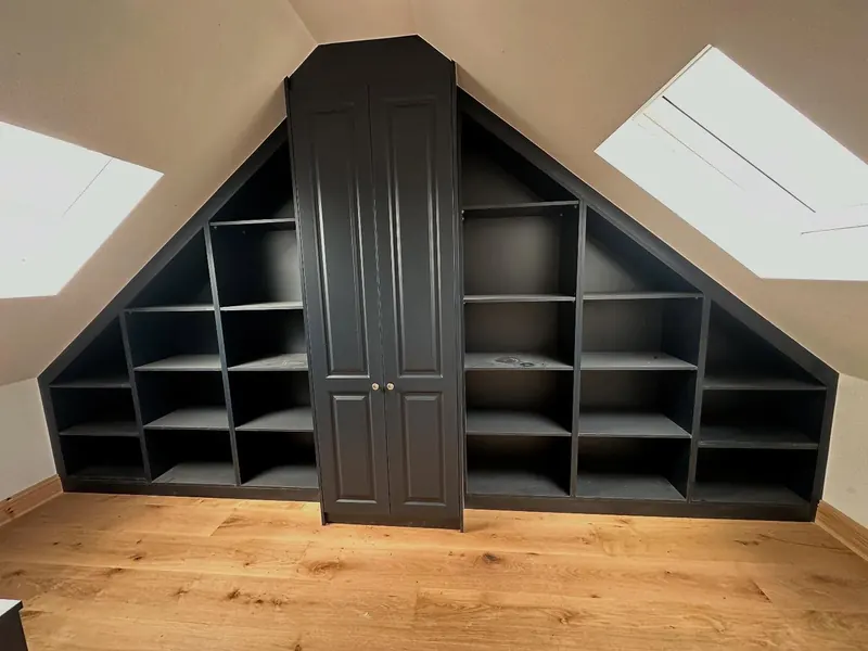 Dark grey attic shelving built around a central cupboard