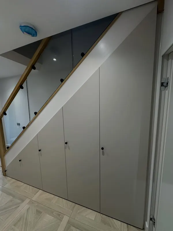 Grey under-stairs cupboards following the line of the staircase