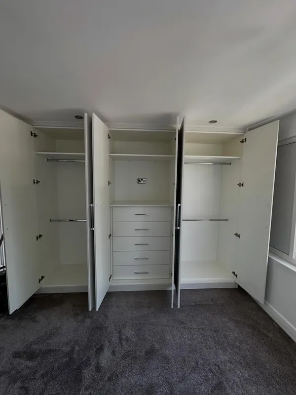 Cream wardrobes open, showing hanging space and drawers