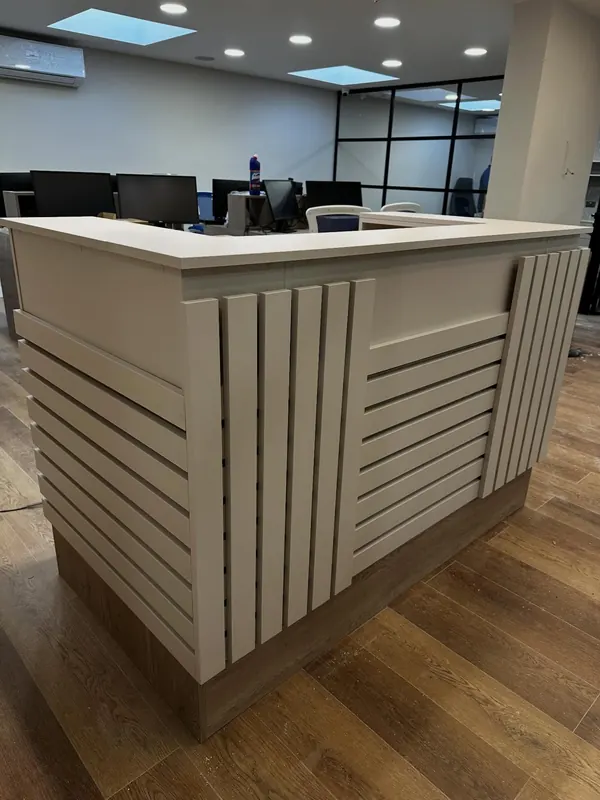 Curved reception desk with slatted front in an office