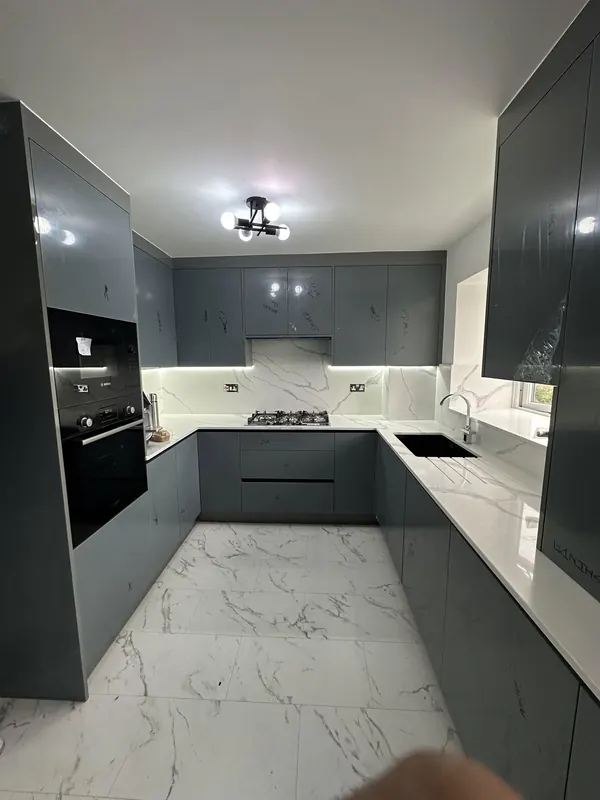 Dark grey handleless kitchen with marble effect worktops