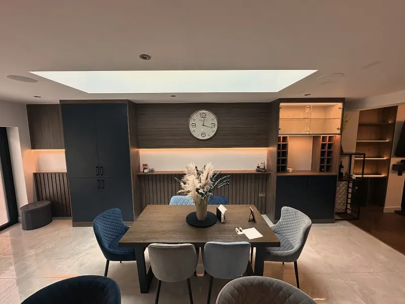 Dining room with dark fitted wall units and a bar area