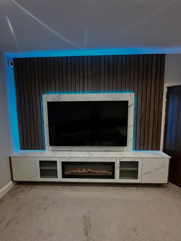 Media wall with slatted panels, fire and blue lighting