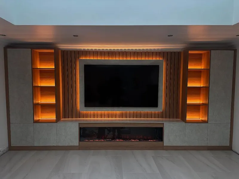 Media wall with warm LED lit shelves either side of the TV