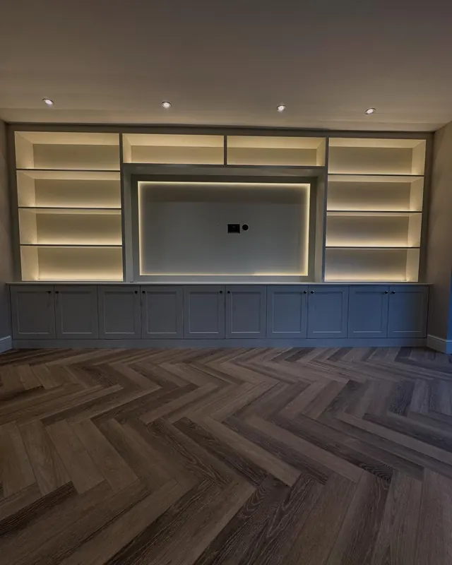 Herringbone floor and a media wall with lit shelving