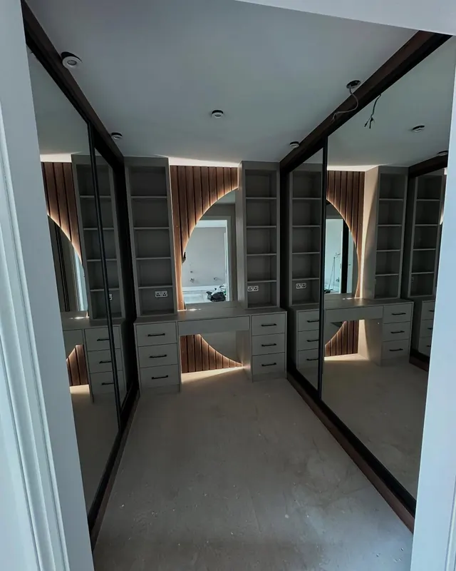 Walk-in wardrobe with mirrored doors and LED lit shelving